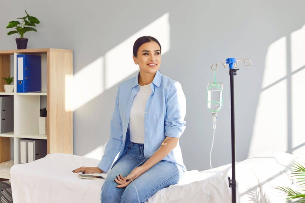 Athletic woman smiling while receiving her NAD+ IV treatment for improved energy and mental clarity